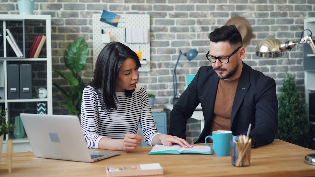 Office Workers Sitting at a Table and Discussing Strategy